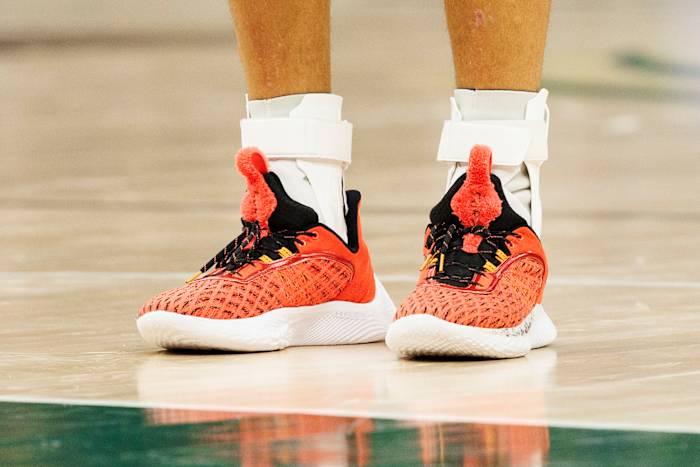 Golden State Warriors point guard Stephen Curry wearing the Sesame Street x Curry Flow 9 'Elmo'.